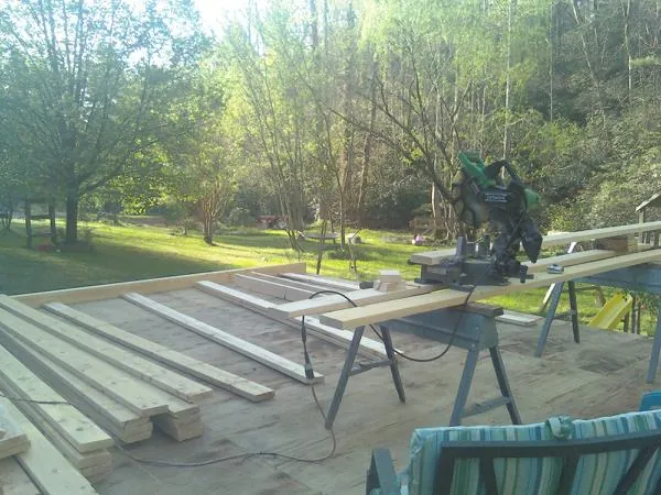 Miter saw and framing lumber on a deck under construction in Madison